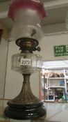 A late Victorian oil lamp with glass font and original shade.