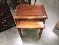 A pair of dark wood stained nest of tables (58cm x 41cm x 49cm high)