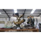 A selection of resin figures including swans, eagles, badgers and Laurel and Hardy.