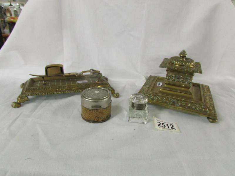 A heavy brass inkwell, a brass stand with candle snuffers and 2 ink wells.