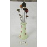 A rose decorated hat pin stand with ten hat pins.