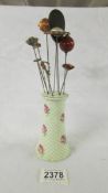 A rose decorated hat pin stand with ten hat pins.