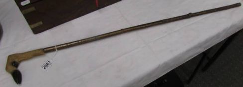 An antique walking stick with deer hoof handle.