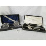 A cased pair of silver rimmed glass salts with spoons,
