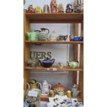 Four shelves of assorted teapots, candles etc.