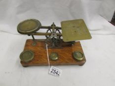 A set of brass postal scales with weights.