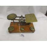 A set of brass postal scales with weights.