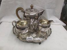 A three piece silver plate tea set on tray.