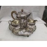 A three piece silver plate tea set on tray.