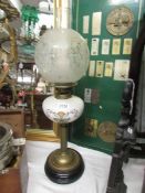 A Victorian oil lamp with pot base, brass column, glass font and original acid etched shade.