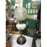 A Victorian oil lamp with pot base, brass column, glass font and original acid etched shade.