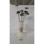 A floral decorated hat pin stand with 8 hat pins.