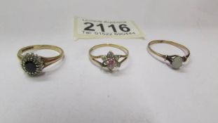 A 9ct gold sapphire ring, a 9ct gold opal ring and a 9ct gold cluster ring missing a stone.