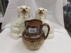A Doulton Lambeth stoneware jug and a pair of Staffordshire spaniels.