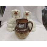 A Doulton Lambeth stoneware jug and a pair of Staffordshire spaniels.