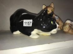 A signed Winstanley black & white crouching cat with glass eyes, size 5,