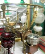 A brass three legged table with glass tops,