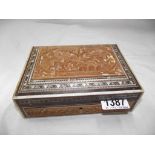 A carved wooden box containing silver watch fobs,