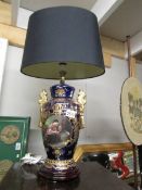 A hand painted classical style table lamp with shade.