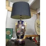 A hand painted classical style table lamp with shade.