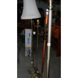 Four brass and wood standard lamps.
