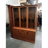 A teak effect wall unit display cabinet (Base 130cm x 42cm x 69cm high,)(Top 130cm x 30cm x 116.