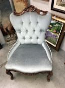 A Victorian style deep buttoned shield back nursing chair with carved mahogany frame