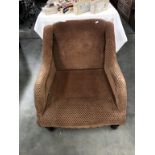 A brown upholstered low armchair