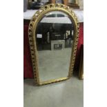 An arched top bevel edged mirror in gilt frame.