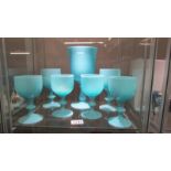A large blue glass goblet and six smaller examples.