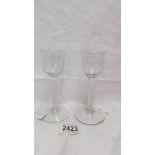 Two antique liquor glasses with spiral stems.