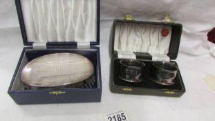 A cased silver plate clothes brush and a cased pair of napkin rings