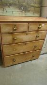 A two over three pine chest of drawers, missing one knob.