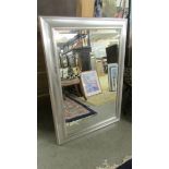 A large bevel edged mirror in silver coloured frame. 106 x 72 cm.