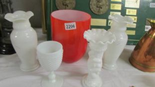 A red glass vase, three white glass vases and a goblet.