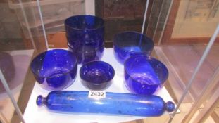 A Bristol blue glass rolling pin and seven blue glass bowls.