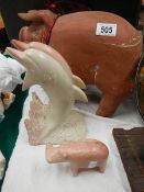 A terracotta pig, a stone dolphin group and a stone rhino.