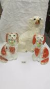 A pair of Staffordshire spaniels and a larger example.