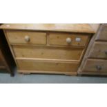 A two over two chest of drawers, missing four knobs.
