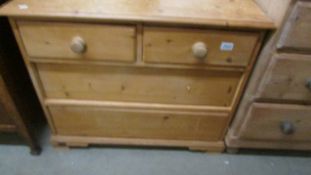 A two over two chest of drawers, missing four knobs.