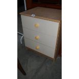 A three drawer bedside chest.