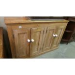 A pine four door cupboard.