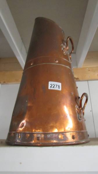 A copper coal scuttle.