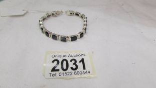 An onyx stone bracelet set with 18 oblong onyx stones in silver.