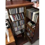 A dark wood stained CD cabinet with in excess of 120 CD's & some cassettes