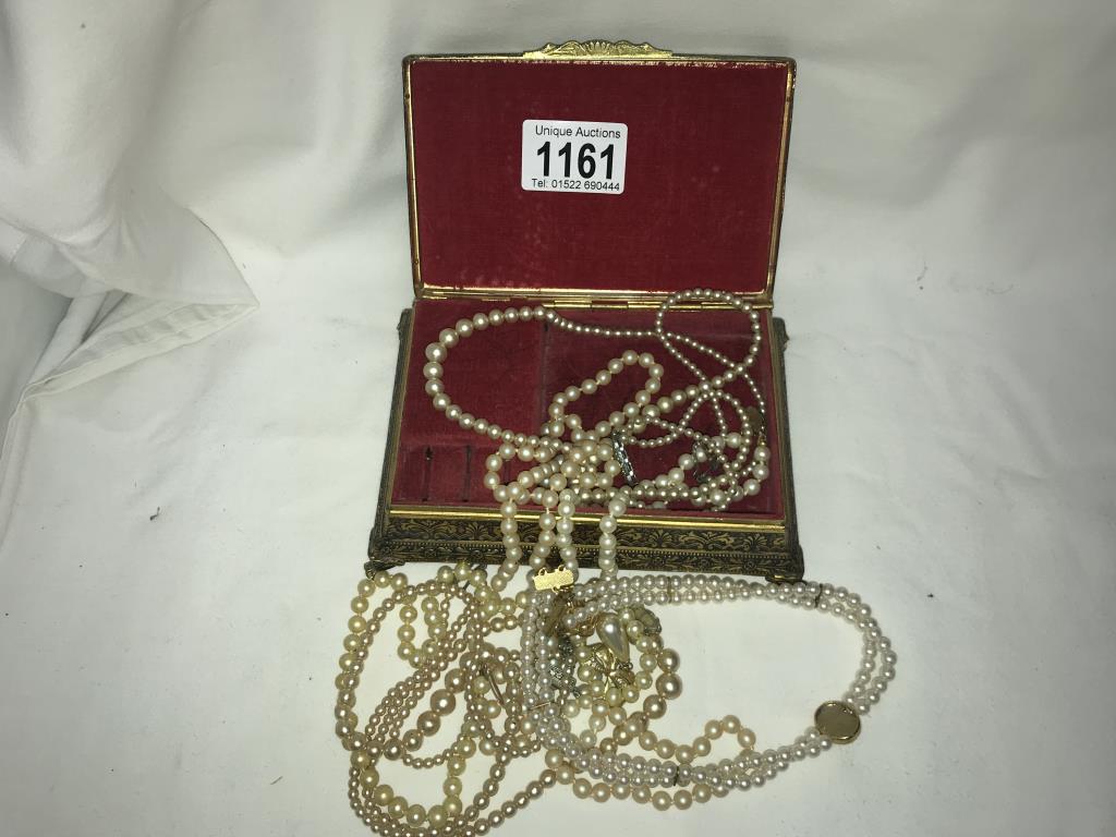 A jewellery box containing pearl necklaces