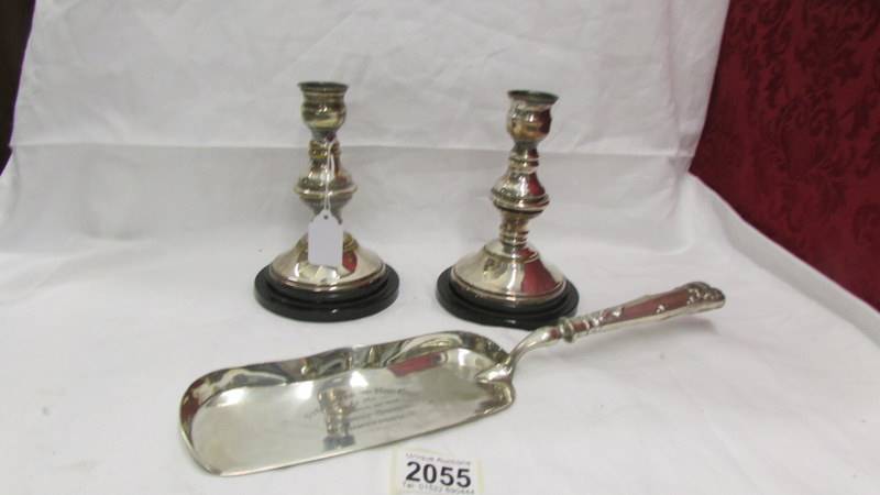 A pair of silver plate candlesticks and a silver plate fish slice.