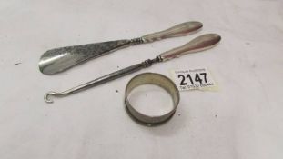 A silver handled button hook, a silver handled shoe horn and a silver napkin ring.