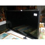 A Polaroid flat screen TV with remote.