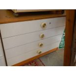 A white four drawer chest.